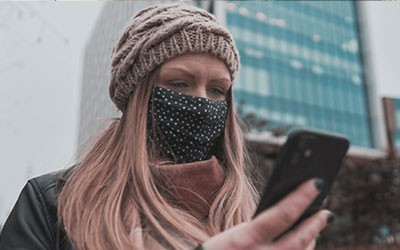 woman wearing a facemask searching on phone